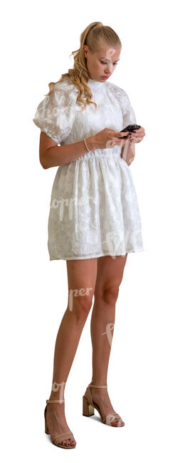 cut out woman in a short white dress standing with a phone in her hand