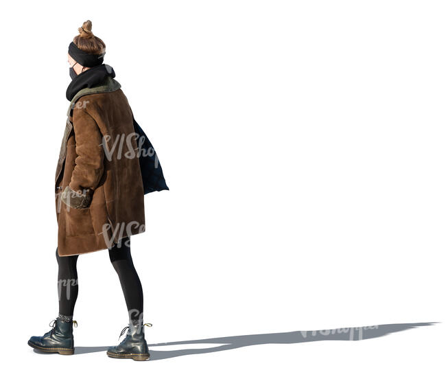 cut out woman in a brown overcoat and wearing a face mask walking