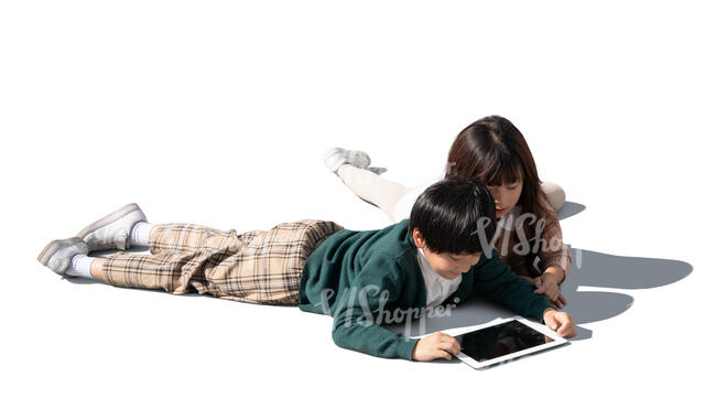 two cut out asian kids lying on the floor and looking at a tablet