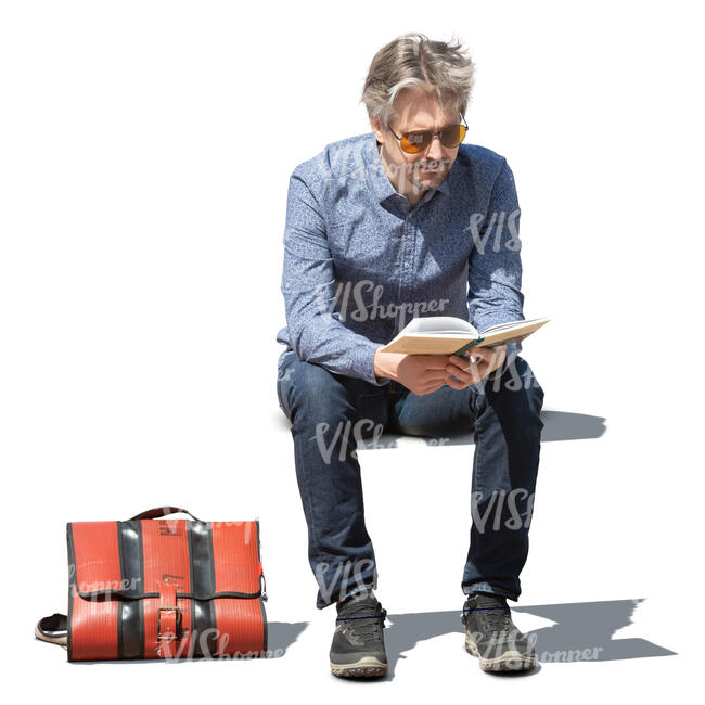 man sitting outside and reading a book