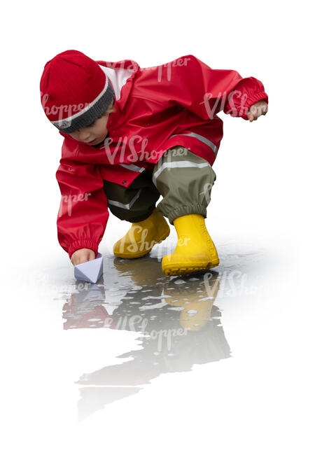 cut out little boy playing with a paper boat in a rain puddle
