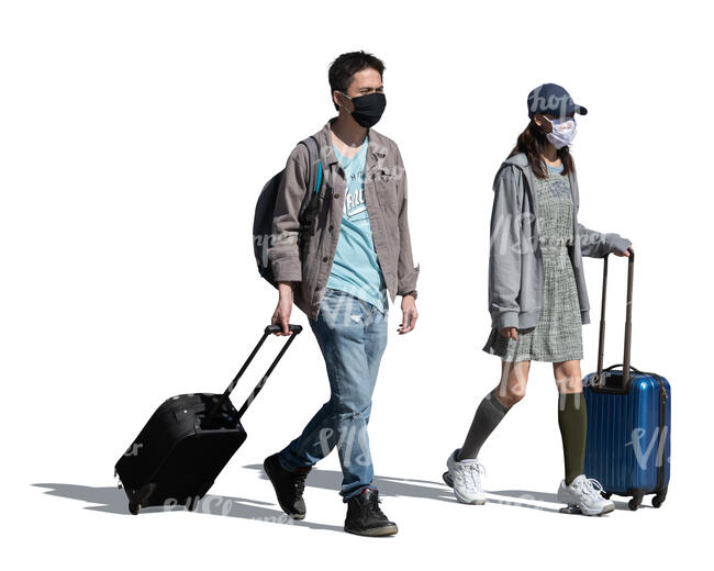 cut out asian man and woman with trolley bags and wearing face masks walking