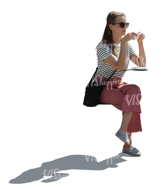 cut out woman sitting outside at a table and drinking coffee