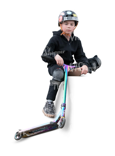 cut out little boy with a scooter sitting in the skatepark