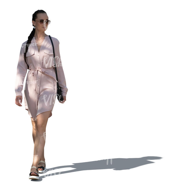cut out woman in a pink summer dress walking in tree shade