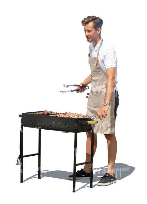 cut out man grilling meat on an outdoor barbeque stove