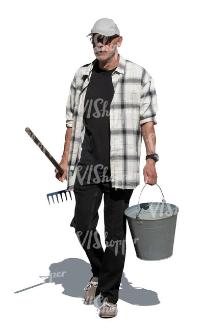 cut out older man walking in the garden carrying a bucket and a rake