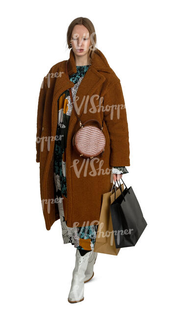 cut out woman in a brown overcoat and with shopping bags walking