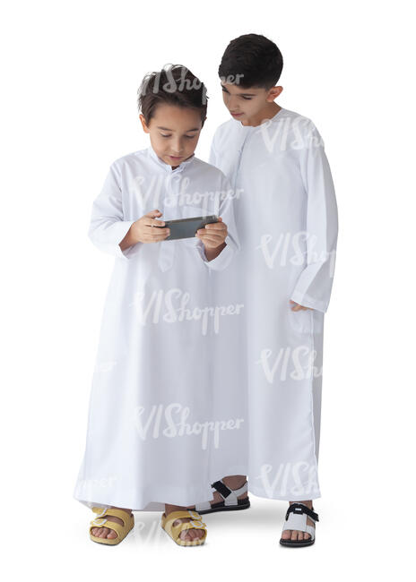 two cut out arab boys dressed in kandoras standing and watching tablet