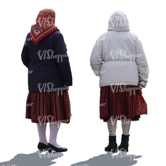 two backlit elderly women in ethnic clothing and winter jackets standing