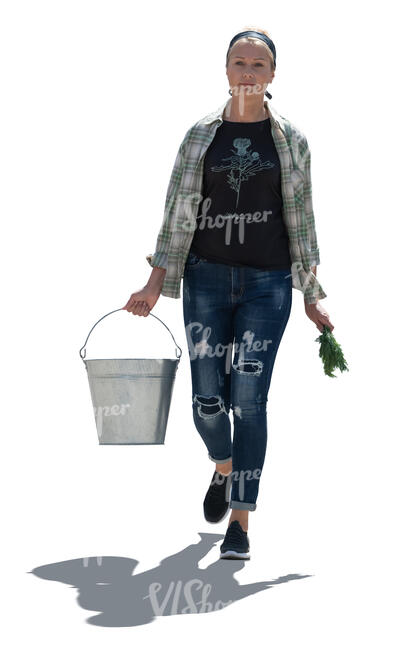 cut out backlit woman working in a garden walking and carrying a bucket