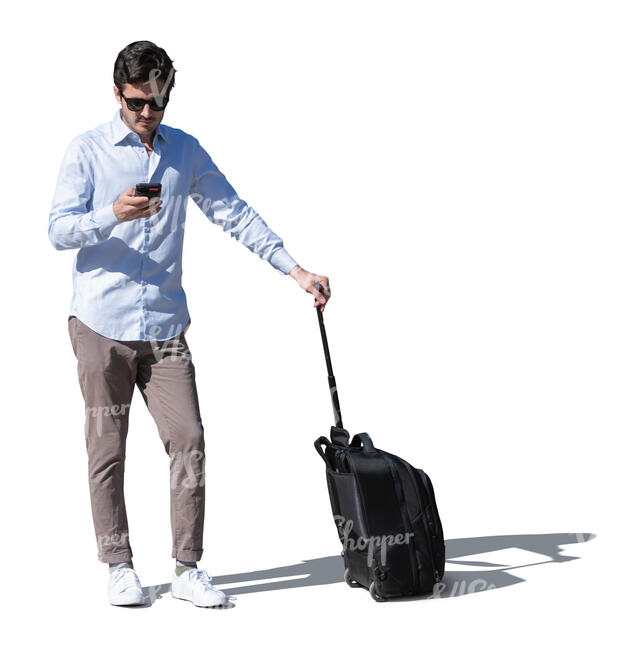 cut out young man with a suitcase standing outside and checking his phone
