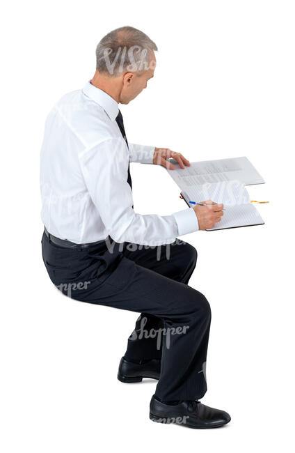 cut out office worker sitting and writing seen from above