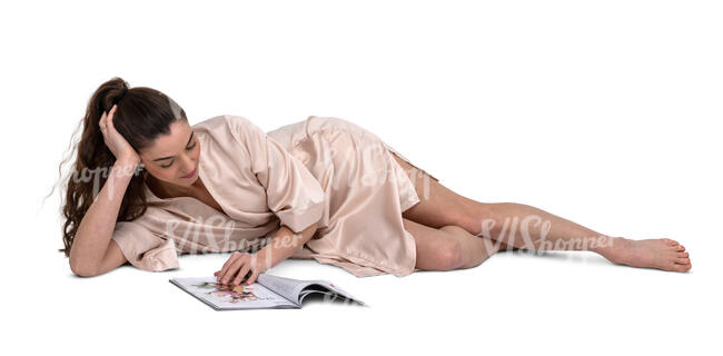 cut out woman in a silky bathrobe lying on a bed and reading