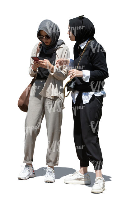 two cut out young muslim women standing and checking their phone