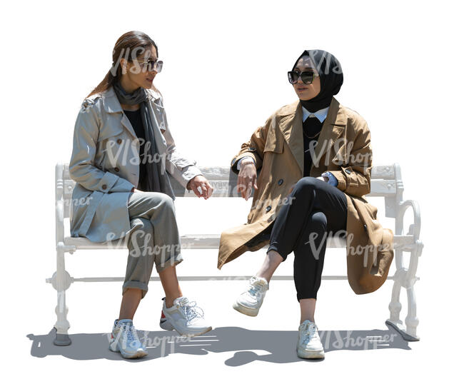 two cut out backlit muslim women sitting and talking