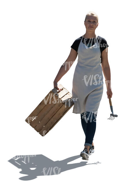 cut out backlit female gardener with a wooden crate walking
