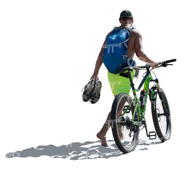 cut out man with a a bike walking on the seaside barefoot