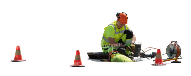 two cut out workmen working in the manhole on the street