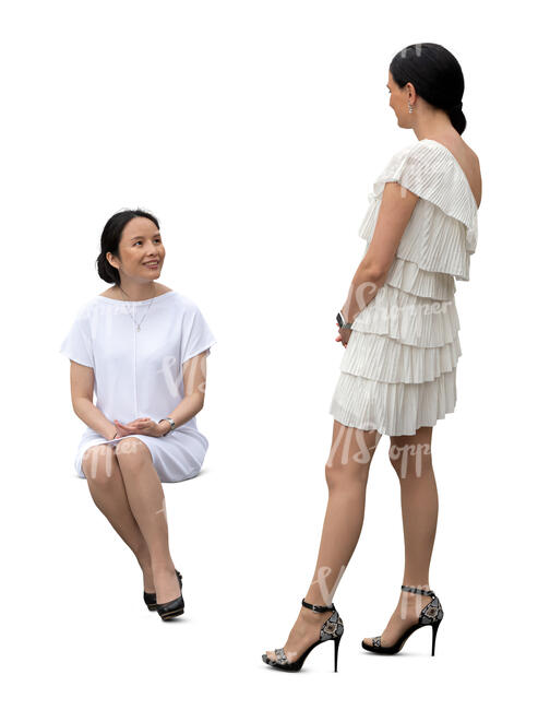 cut out woman sitting and talking to another woman standing next to her