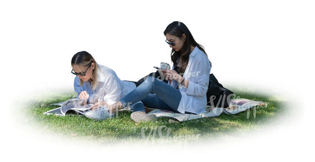 two cut out women relaxing in the park on the grass