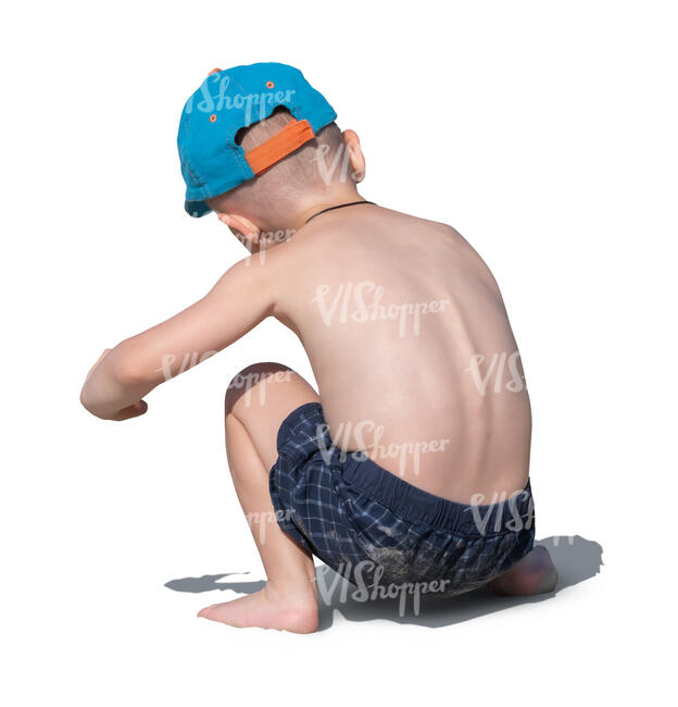cut out little boy squattig and playing on the beach