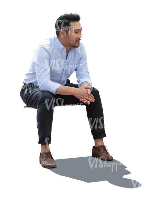 backlit asian man sitting