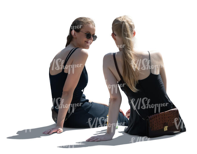 two backlit women sitting and talking seen from back angle