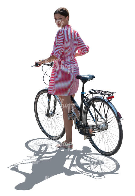 backlit woman with a bike standing and looking bacg over her shoulder