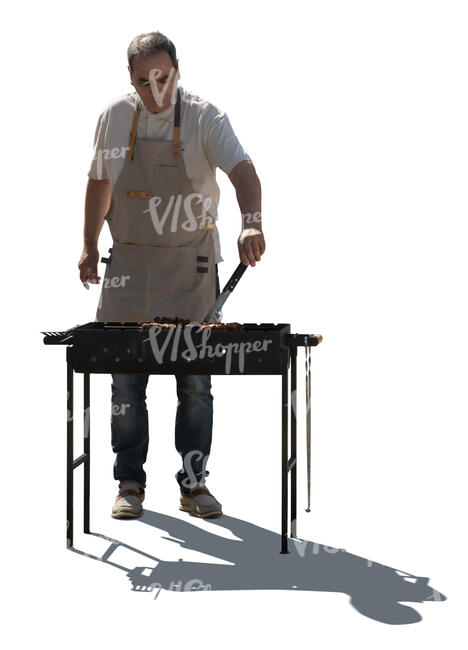 cut out backlit man cooking meat on barbeque grill