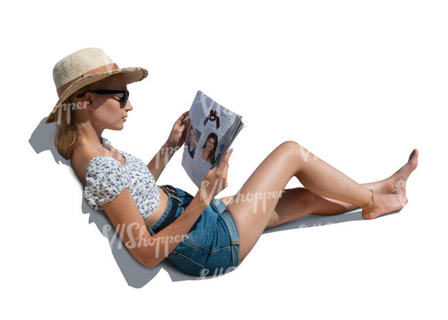 woman lying on a sofa outside and reading a magazine