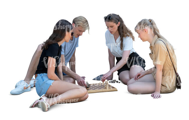 group of young people sitting on the ground and playing chess