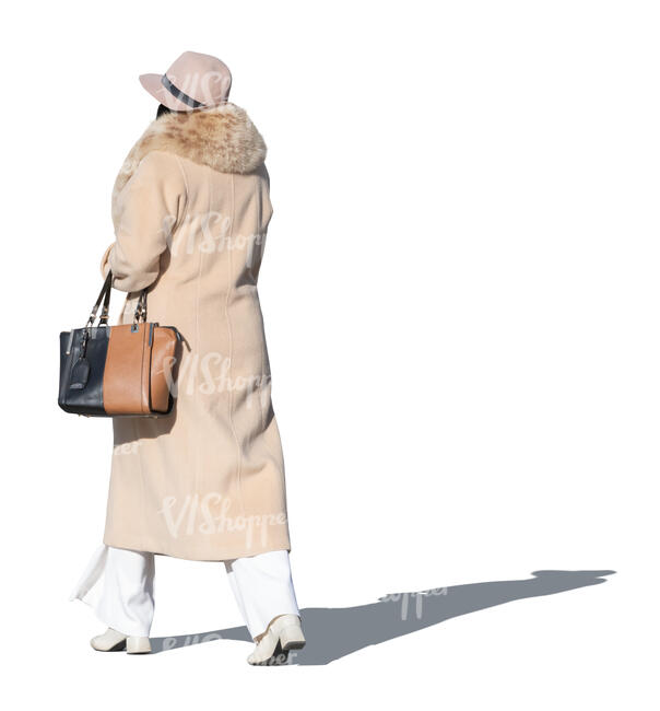 lady in a coat and wearing a hat walking in autumn