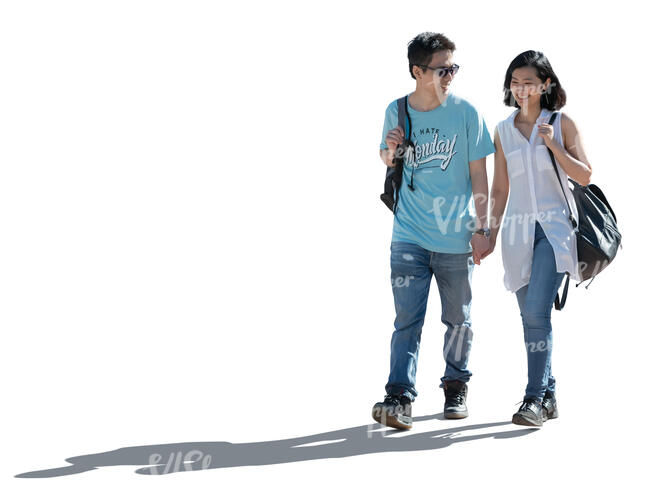 happy backlit asian couple walking hand in hand