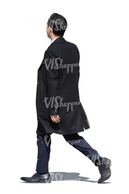 asian businessman wearing a suit and a black overcoat walking