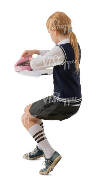 cut out schoolgirl sitting at a desk and writing