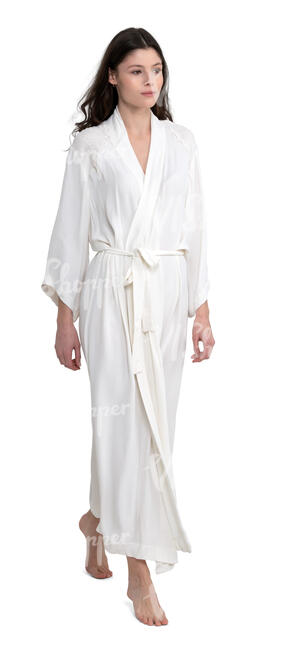woman in a white silky bathrobe walking barefoot