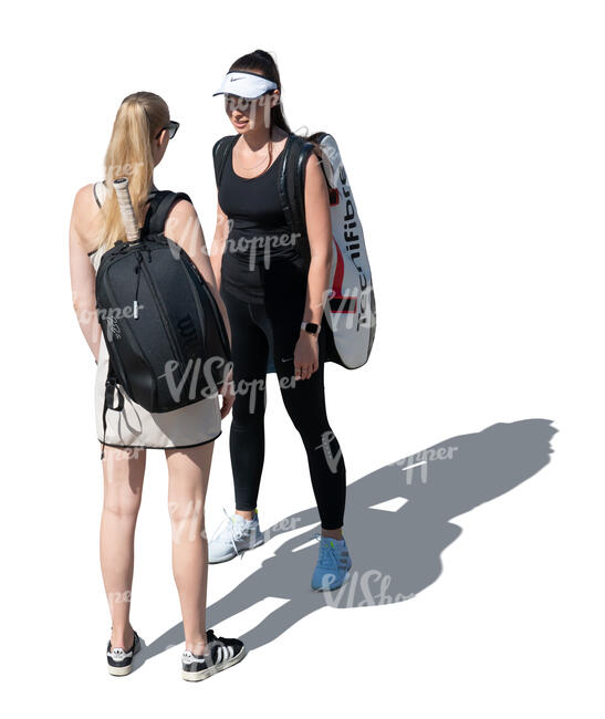 two women with tennis equipment standing and talking seen from higher angle