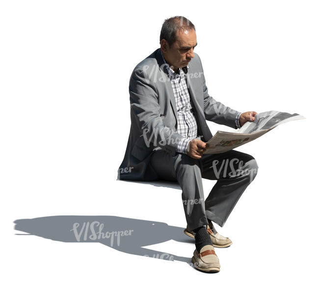 older man in a grey suit sitting and reading a newspaper
