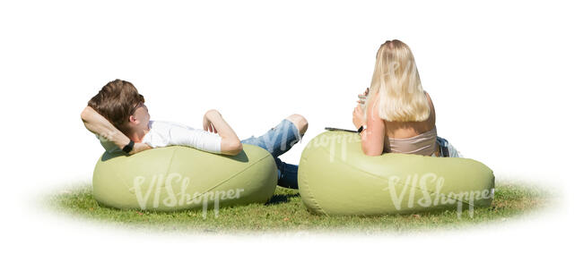 man and woman lying on the bean chairs outside on the grass