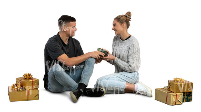 man and woman sitting on the floor and exchanging christmas gifts