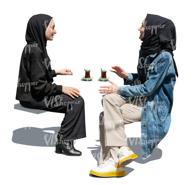 two cut out muslim woman sitting and drinking tea