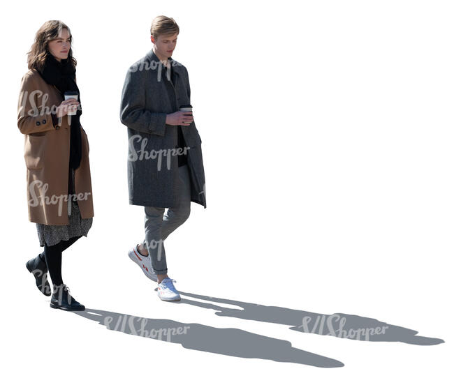 two backlit women with coffee cups walking
