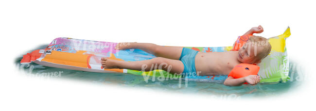 little boy relaxing on an air mattress in a pool