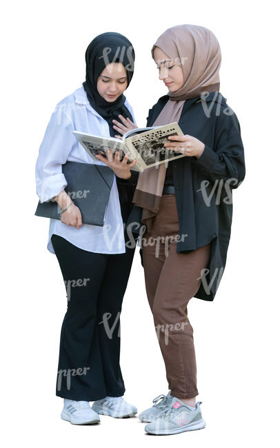 two muslim girls standing and reading a book