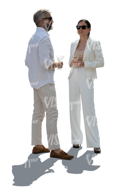 backlit man and woman wering white summer clothes standing and drinking martinis