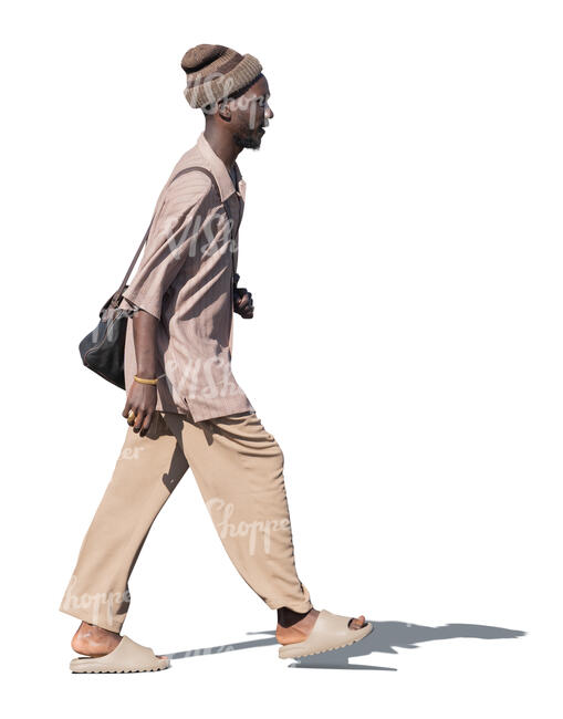 black man in light brown outfit walking