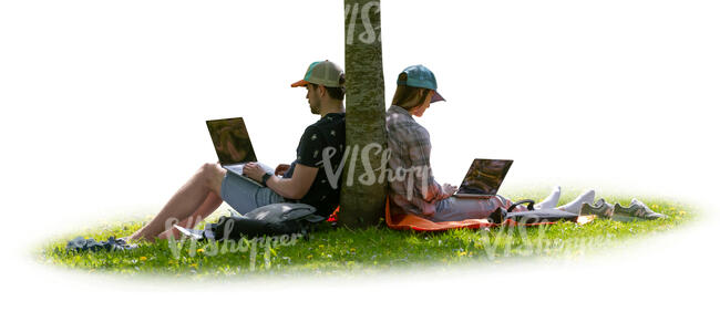 two people with computers sitting under a tree