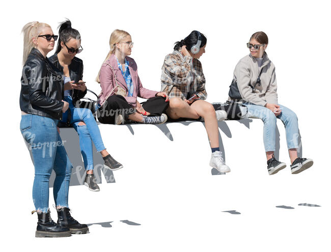 group of teenage girls sitting on a street balustrade