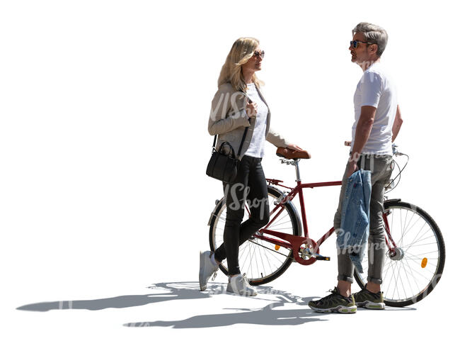 backlit man and woman with a bike standing